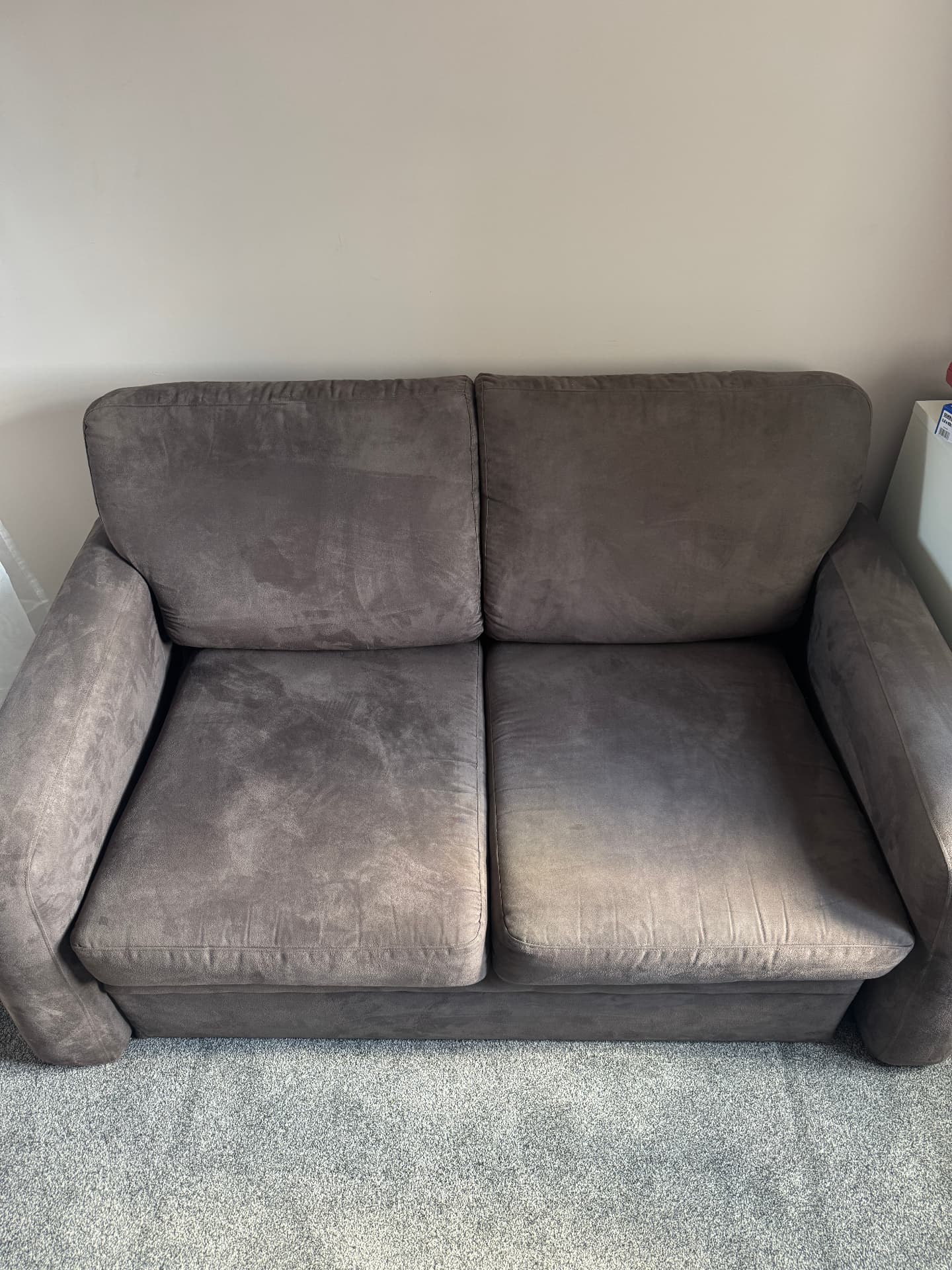 Recently cleaned grey two seater sofa bed in a Colchester home